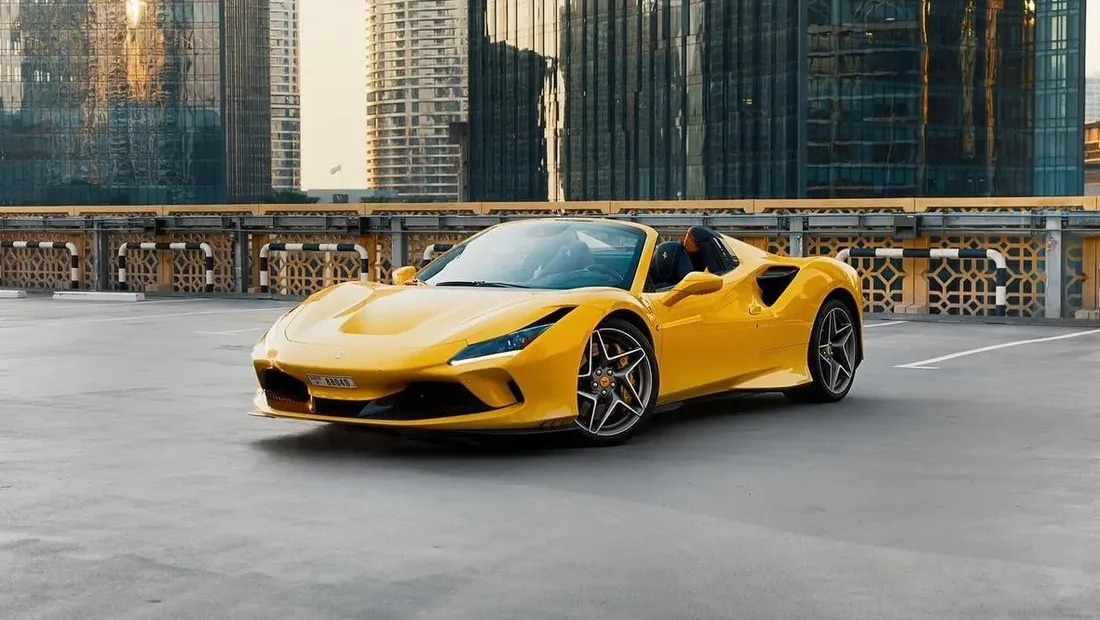 Yellow Ferrari F8 Spider parked on a Dubai rooftop with the Downtown skyline behind it